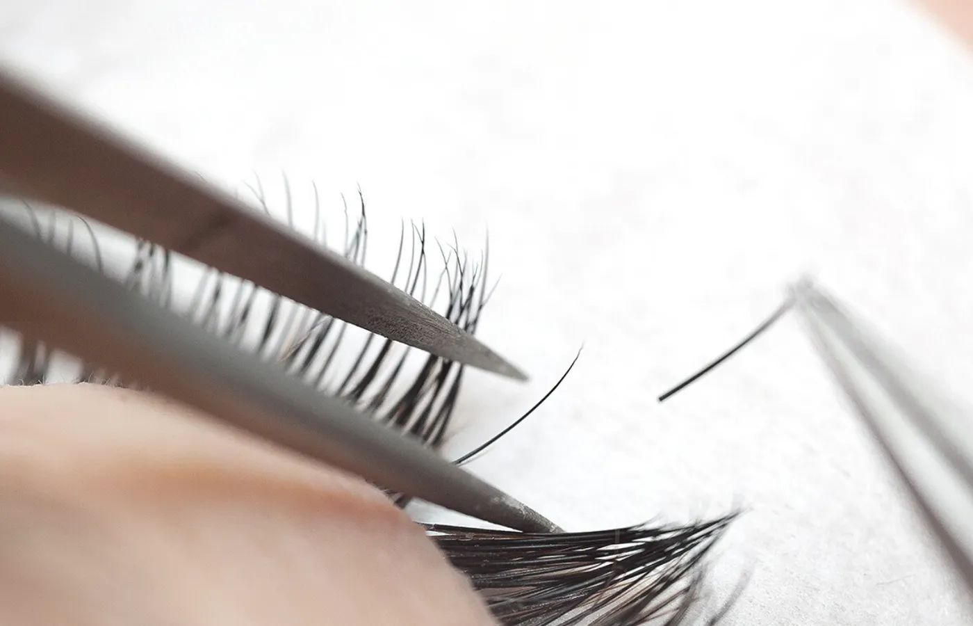 Eyelash extensions being applied with tweezers